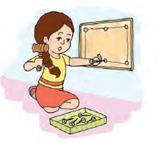 A girl is fixing a nail in a board using a hand tool called hammer. There are five more nails in a box kept near the girl.