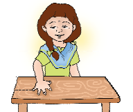 A girl is measuring the length of a table with her hands.