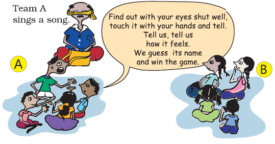 The man with his eyes covered with a cloth is sitting with a bag in front of him and few children are sitting in groups of two, the first group is team A, which is singing a song and the second group is Team B, who is listening.