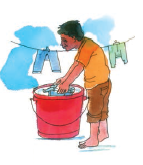 A man is taking out clothes from a bucket and  putting them on a clothesline for drying.