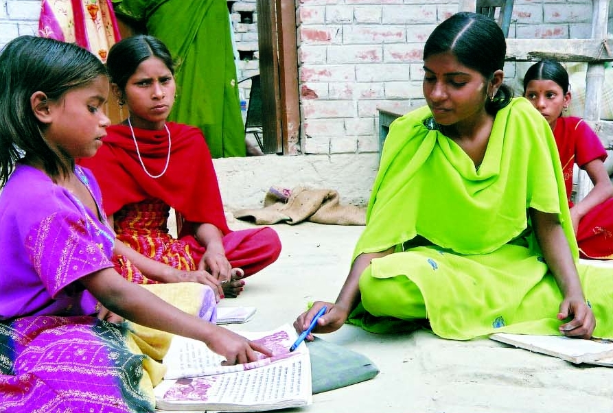 Few girls sitting on the floor and studying.