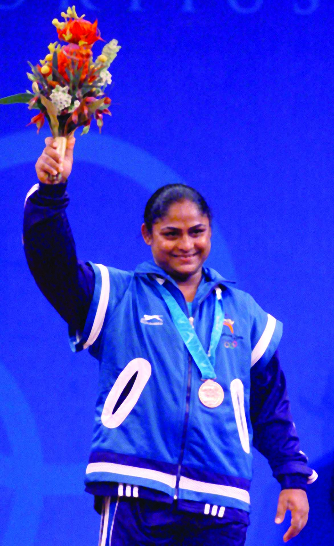 Indian weight lifter Karnam Malleshwari raising a bouquet in her hand. 