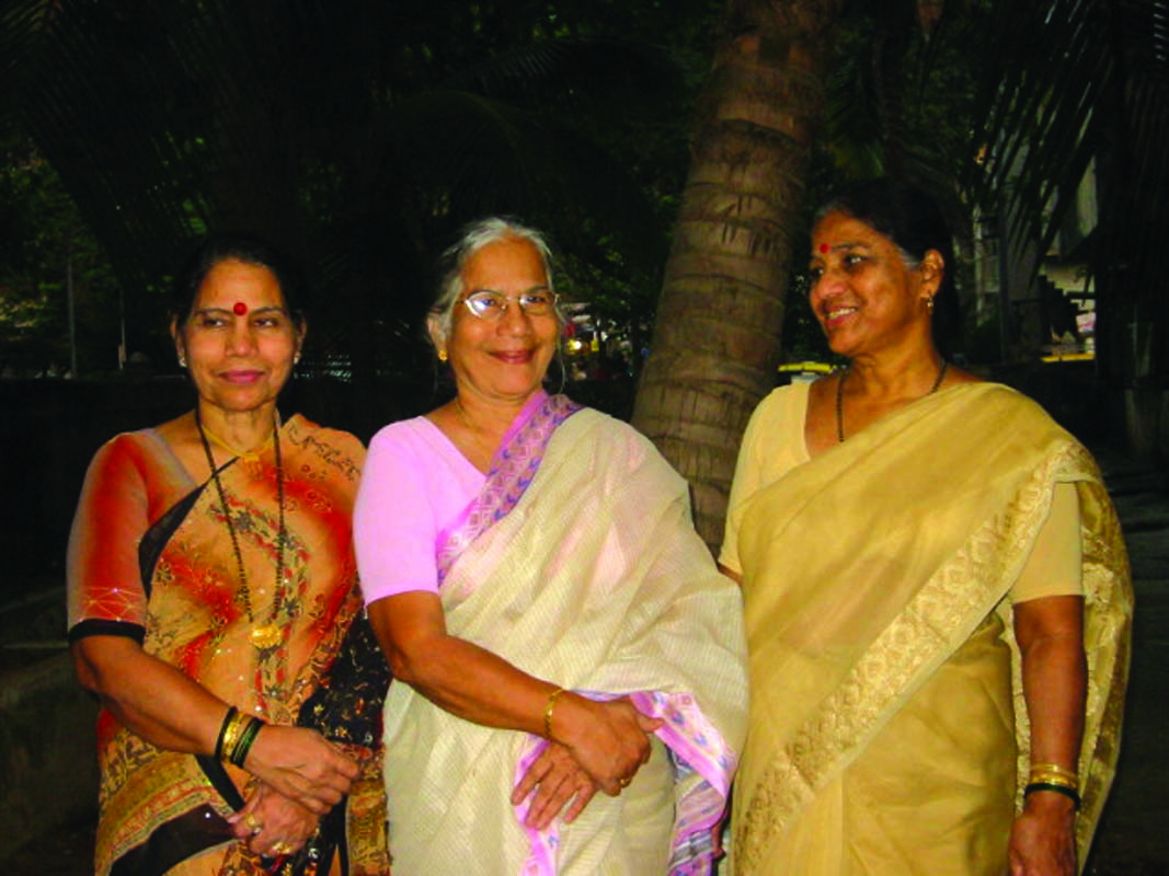 Few aged females standing and smiling. 