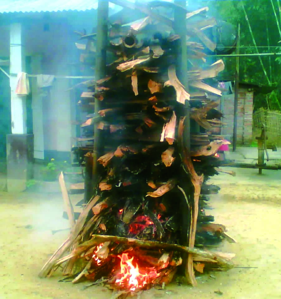 Wood logs arranged vertically with fire below, called as Mezi. 