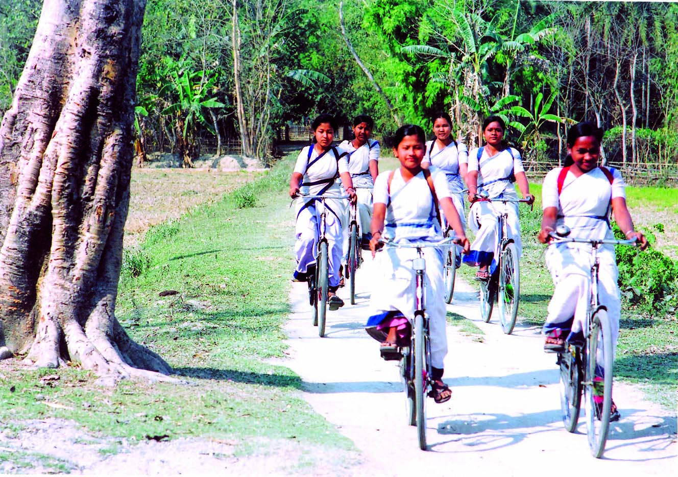 कुछ स्कूल की लड़कियां साइकिल चल रही हैं 