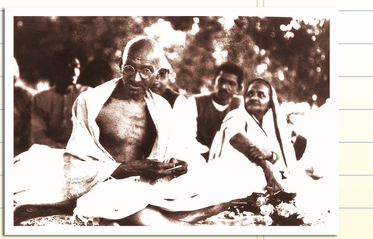 गांधी जी और कुछ लोग बैठे हैं