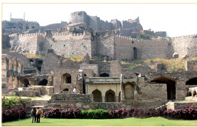 गोलकोंडा  किले का चित्र दिखाया गया है। यह एक विशाल किला है जिसमें विभिन्न स्तरों पर कई संरचनाएं बनी हैं और किले के सामने एक बगीचा है। 