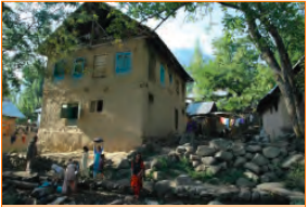 पत्थर, ईंटों और ढलान वाली छतों से बना एक पुराना घर।