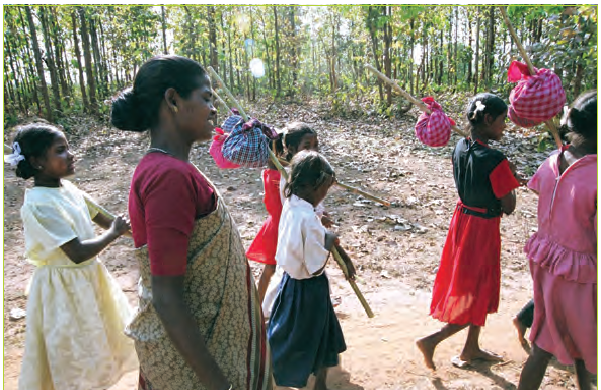कुछ महिलाएं और लड़कियां हाथों में डंडों से बंधी पोटली लेकर जंगल में घूम रही हैं।