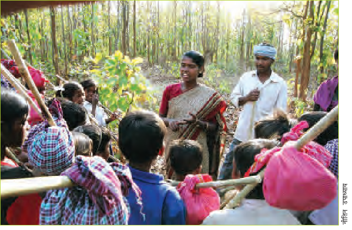 जंगल में छोटे बच्चों से बात करती महिला।