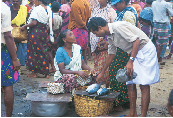 बाजार में मछली बेचती महिला।