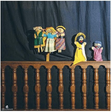 A bedsheet can also be used as a curtain to cover the puppeteer. In case the puppeteer uses strings, the sheet can be tied to a string behind the table like a curtain.