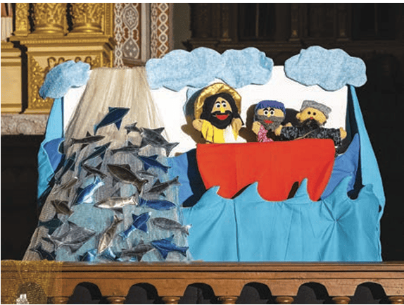 A bedsheet can also be used as a curtain to cover the puppeteer. In case the puppeteer uses strings, the sheet can be tied to a string behind the table like a curtain.