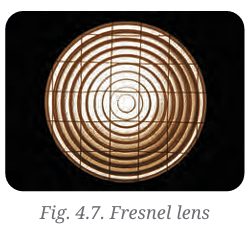 Close-up view of a glass lens showing concentric circular ridges characteristic of a Fresnel light.