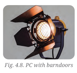 A professional theater spotlight fixture equipped with open four-leaf barndoors attached to the front.
