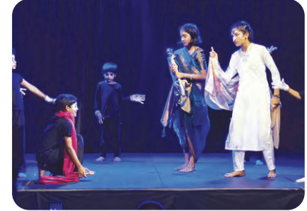 Children performing on a dark stage