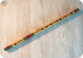 A wooden object with a red, yellow, and blue striped pattern is laying on a wooden floor.  AI generated content