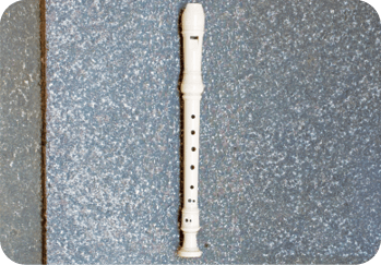 A white flute is laying on a black surface.  AI generated content